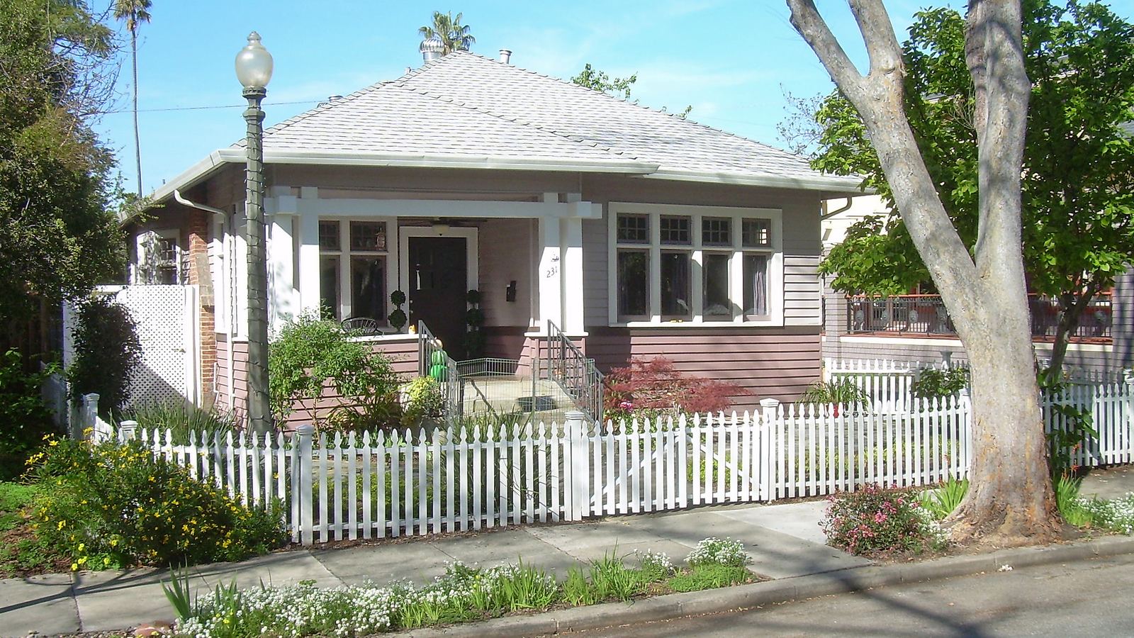 A Craftsman bungalow with a white picket fence