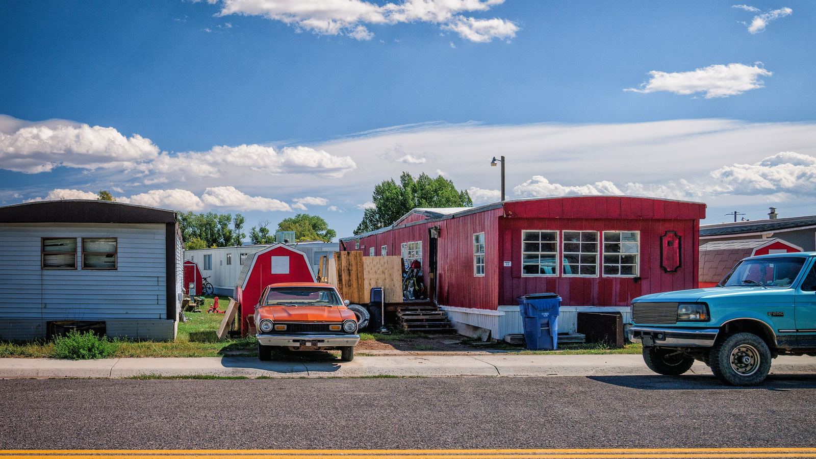 Mobile homes and parked cars along a street in a manufactured-home community