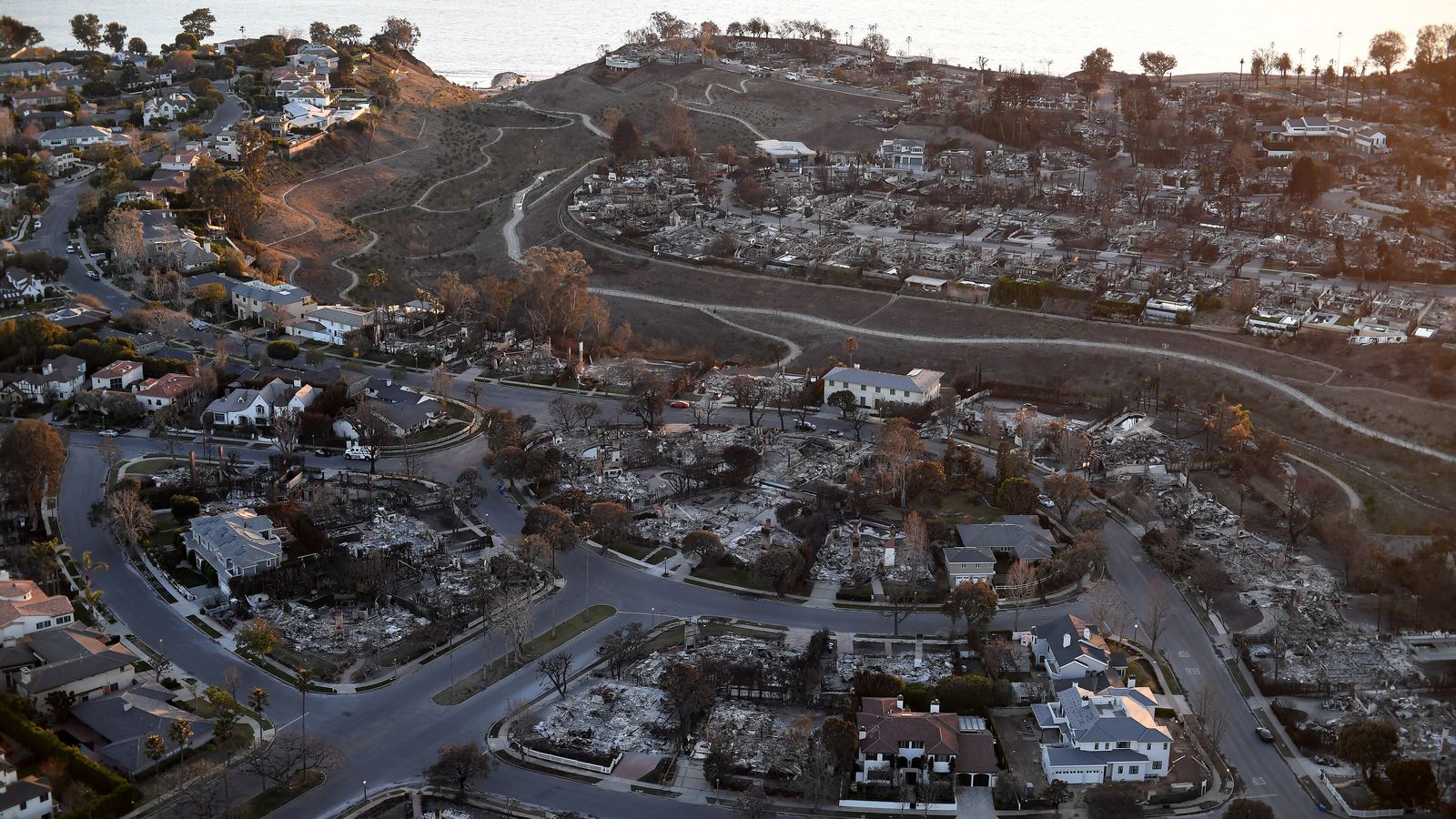 Aerial view of a hillside neighborhood where many homes were destroyed by wildfire