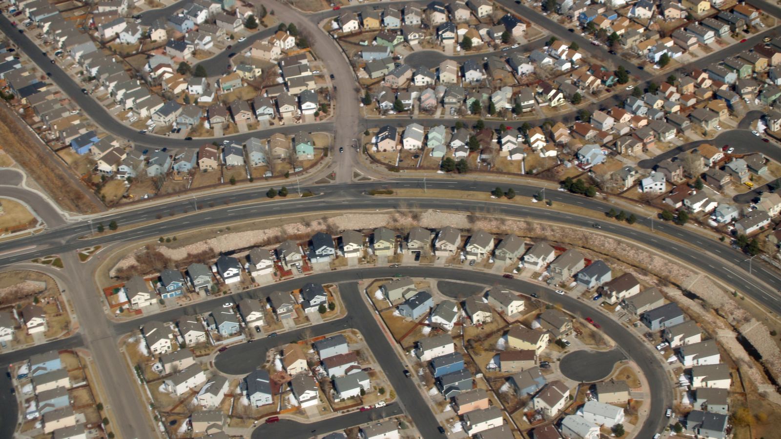 Aerial view of curving streets lined with tract homes in a suburban subdivision