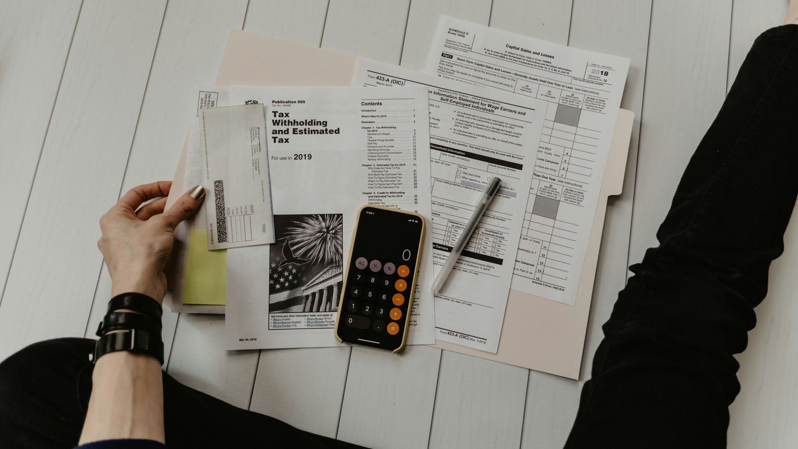 IRS tax forms, a calculator and a pen spread on a table